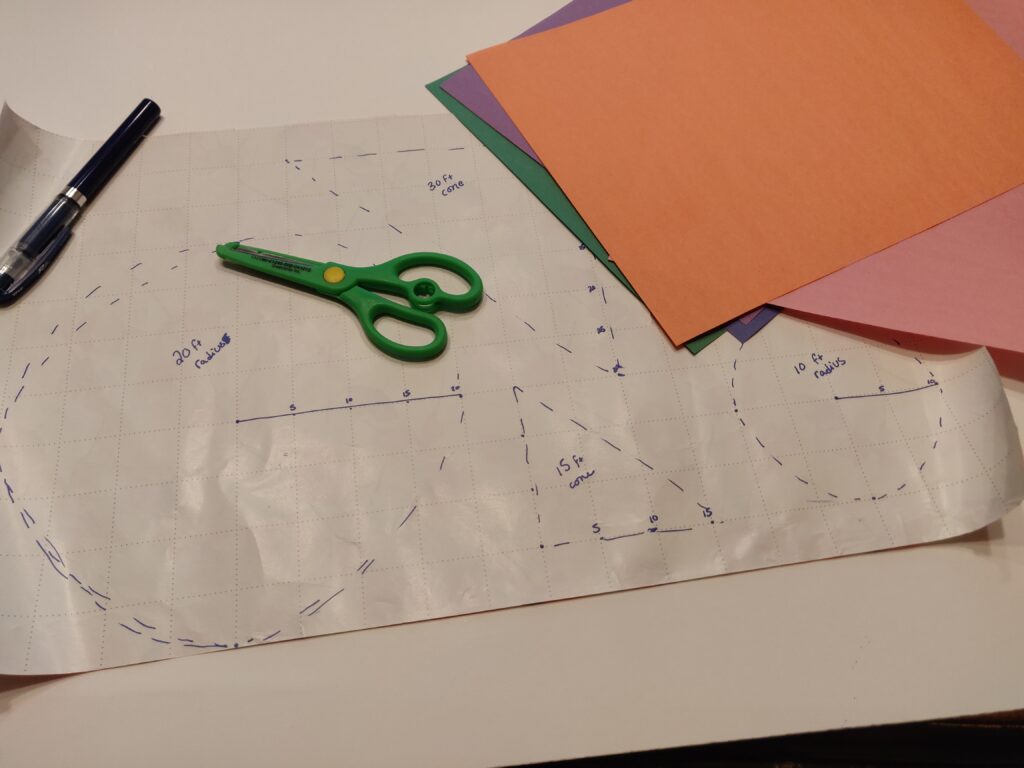 TTRPG AoE game aides - craft materials (grid paper, construction paper, scissors, and pen) with shapes drawn on grid paper